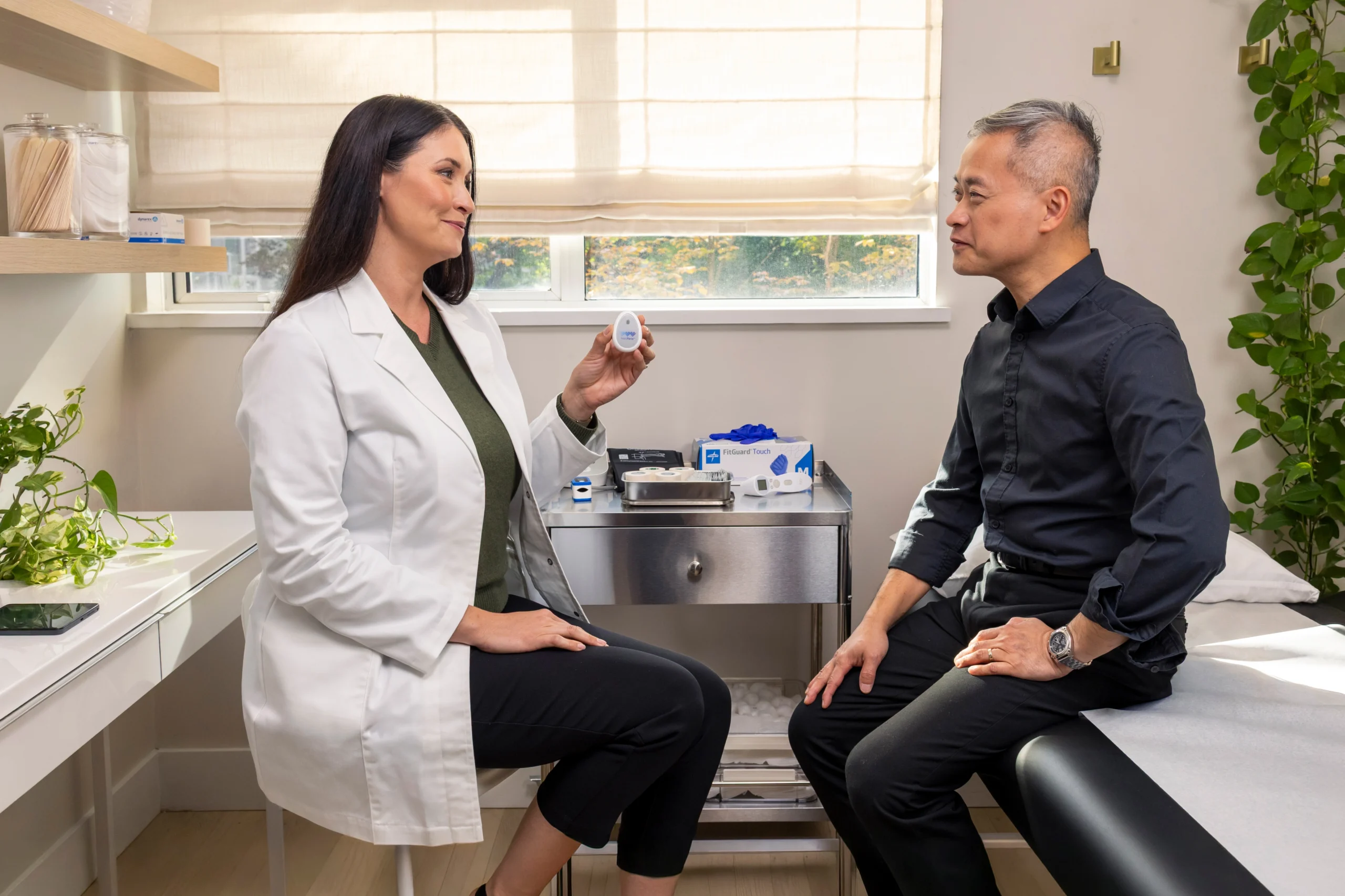 Doctor showing the CardioClin device during a patient consultation