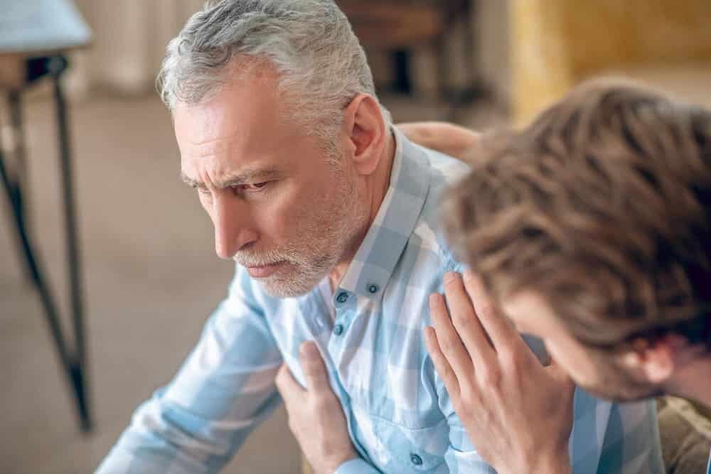 Man looking distressed while holding his chest indicating heart issues